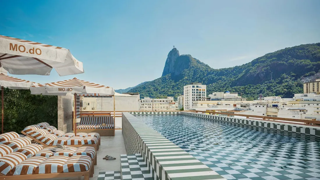 Piscina do rooftop do MO.dO Design Living Botafogo com piso xadrez e vista para o Cristo Redentor