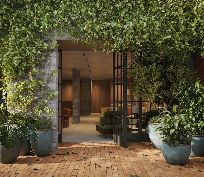 Entrada do MO.dO Design Living Botafogo com pergolado coberto de vegetação